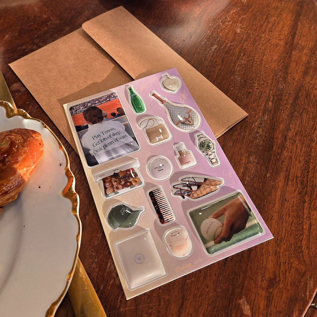 Curated 3D Phone Jewelry Kit. High-gloss aesthetic decals featuring luxury watches, designer bags, vintage tennis charms, and resort essentials. Glass-like finish, jewelry-grade resin. Old Money and Sport Luxe aesthetic. Neutral lavender palette.