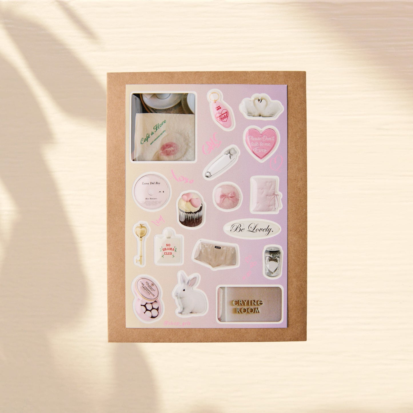 Set of premium 3d domed stickers on a beige background. Glossy images of a cafe, a fluffy bunny, white swans, a bottle with the inscription "No Drama Club," the inscription "Crying Room," a golden key, a hairpin, and a heart.